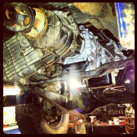 1995 Ford Bronco - The undercarriage of a vehicle is shown, focusing on the transmission and drivetrain components.