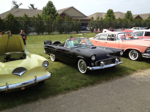 1988 Ford Bronco - A black 1957 Ford Thunderbird convertible is parked next to other classic cars at a show.
