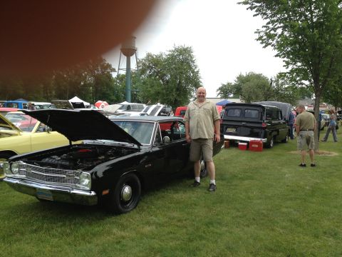 1988 Ford Bronco - A black 1970 Dodge Dart is displayed with its hood open at an outdoor car show.