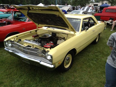 1988 Ford Bronco - A yellow coupe with its hood open is displayed on the grass at an outdoor car show.