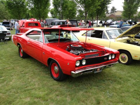 1988 Ford Bronco - A red 1968 Dodge Coronet is displayed with its hood open at an outdoor car show.