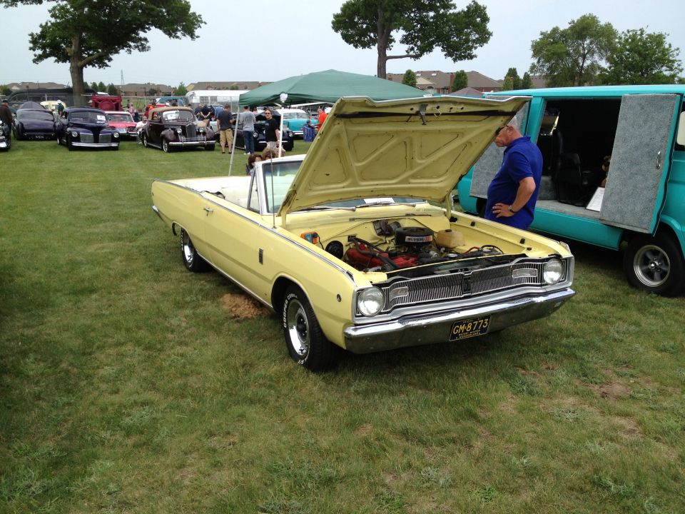 Yellow convertible with hood open, showing engine. License plate reads GM 8775
