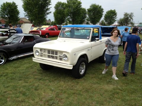 1988 Ford Bronco - A white 1973 Ford Bronco with a blue top is displayed at an outdoor car show.