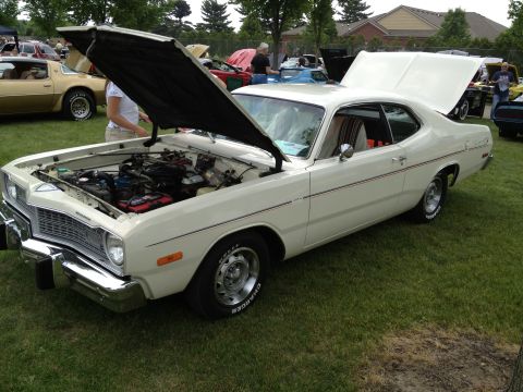 1988 Ford Bronco - A white coupe with its hood open is displayed on a grassy field at a car show.