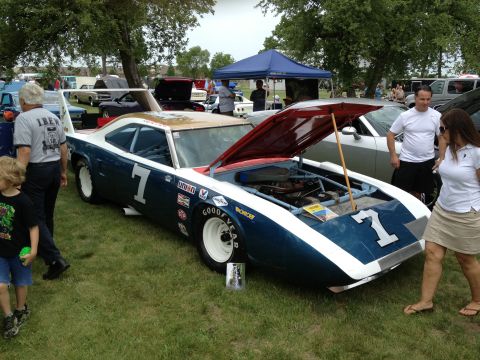 1988 Ford Bronco - A blue and white race car with the number 7 is displayed with its hood open at an outdoor car show.