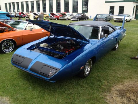 1988 Ford Bronco - A blue 1970 Plymouth Superbird is displayed with its hood open at a car show.