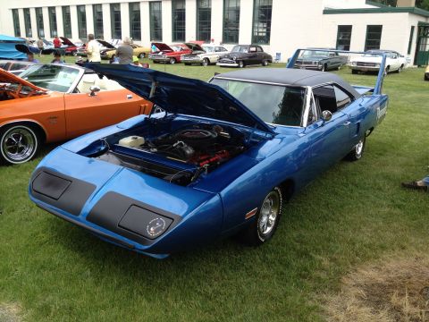 1988 Ford Bronco - A blue 1970 Plymouth Superbird is displayed with its hood open at an outdoor car show.