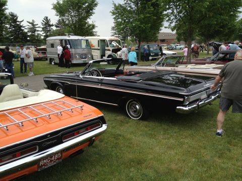 1988 Ford Bronco - A black convertible is parked on grass at an outdoor car show with other vehicles present.