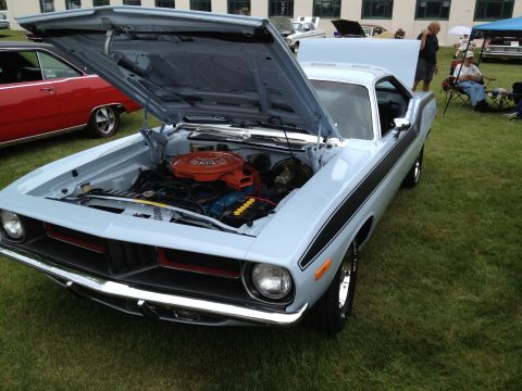 1988 Ford Bronco - A light blue 1970 Plymouth Barracuda is displayed with its hood open at an outdoor car show.