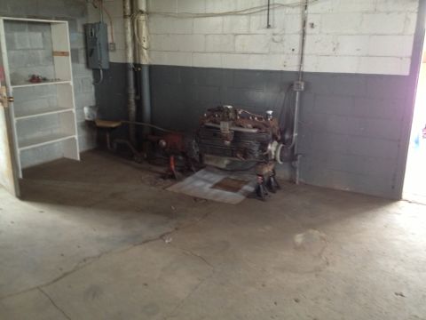 1988 Ford Bronco - Engine and transmission assembly resting on jack stands in a garage setting.