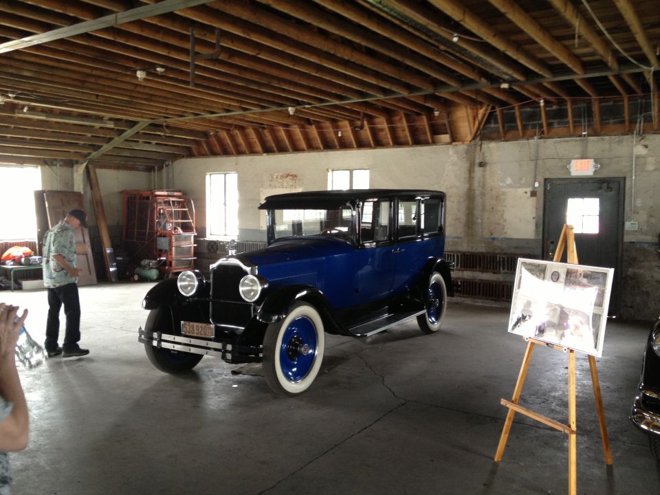 Blue sedan with black roof and fenders, white-wall tires, and a license plate reading '6-18 520'