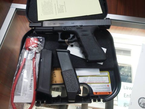 1988 Ford Bronco - A Glock 34 pistol is displayed in its case alongside two magazines and a red cable lock, with various instruction manuals visible.