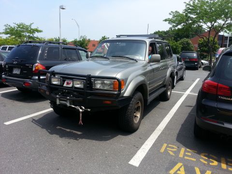 1987 Toyota 4Runner - A silver Toyota Land Cruiser is parked in a lot, surrounded by other vehicles.