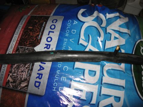 1994 Ford Bronco - A bicycle inner tube lies on top of a bag of mulch.