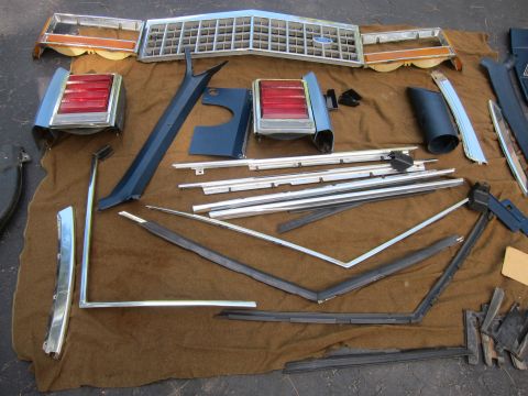 2001 Ford Crown Victoria - Various car parts are displayed on a brown tarp, suggesting a disassembled vehicle.