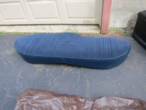 2001 Ford Crown Victoria - A blue car seat with a ribbed pattern is placed on the ground in front of a garage door.