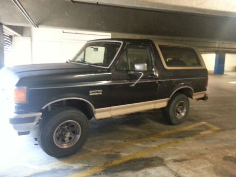 1989 Ford Bronco - This 1989 Ford Bronco is seen parked in a garage, showing its distinctive two-tone paint scheme.