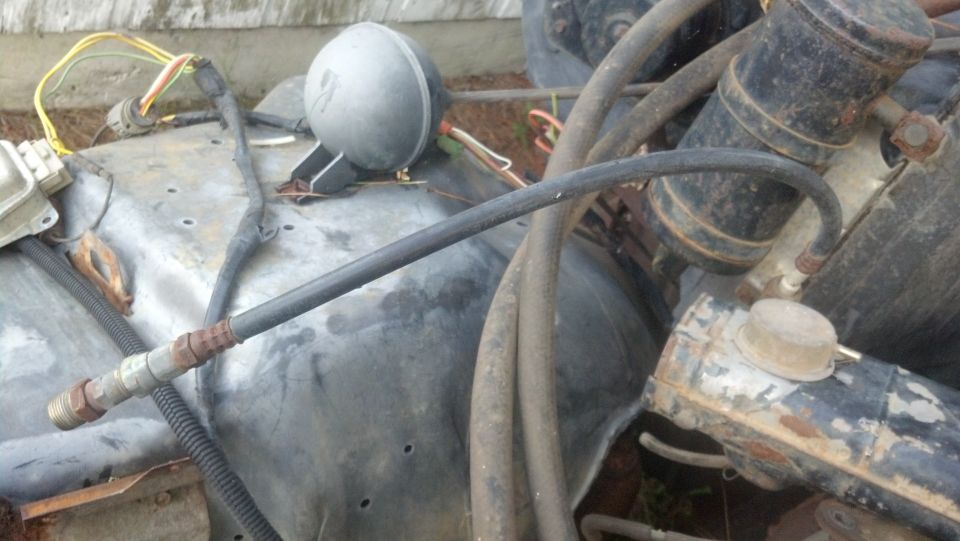 close-up of engine compartment with hoses, wires, and a round component