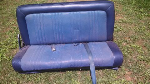 1979 Ford Bronco - A blue bench seat with a two-tone design and integrated seatbelts sits on grass.