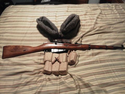 1988 Ford Bronco - A rifle, ammunition clips, and a fur hat are arranged on a striped surface.