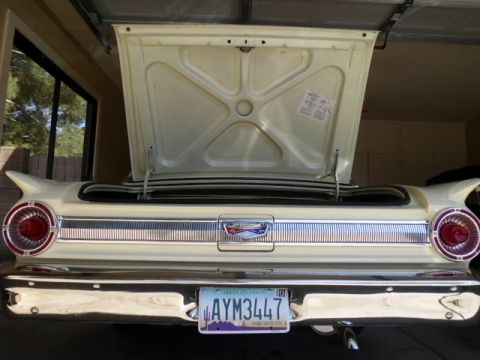 1963 Ford Fairlane - The trunk lid of a vintage Ford is open, revealing the interior and a sticker on the underside.