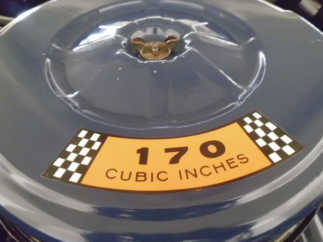 Blue engine air cleaner lid with orange sticker showing '170 CUBIC INCHES' and checkered flags