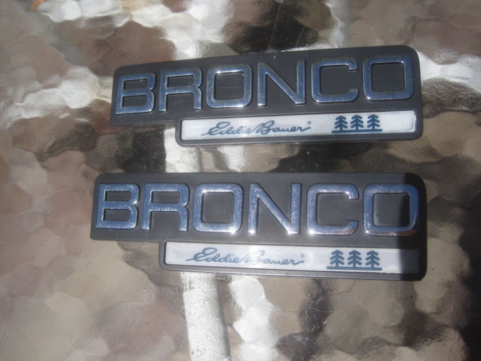 Two Ford Bronco Eddie Bauer emblems with pine trees