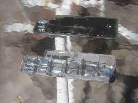 1993 Ford Bronco - Two Chevrolet emblems, one black and one chrome, are shown on a reflective surface.