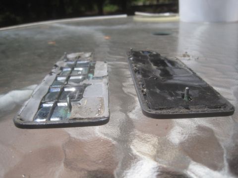 1993 Ford Bronco - These two car emblems appear to be heavily damaged and weathered.