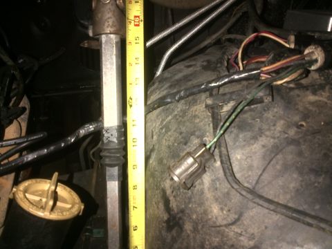 1980 Ford F-150 - A measurement is taken next to the steering column shaft, with various wires and engine parts visible in the background.