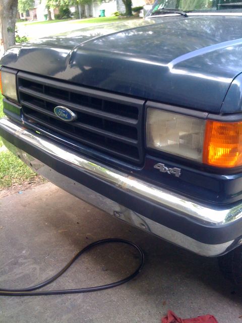 1988 Ford Bronco - Close-up of a Ford truck's front grille and headlights, showing the 4x4 emblem.