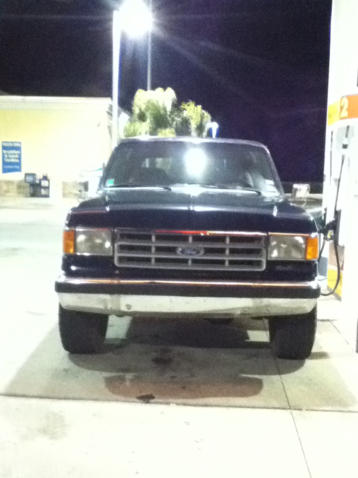 Front view of a 1987 Ford Bronco at a gas station