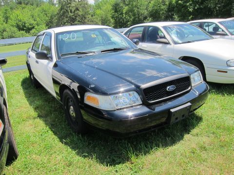2001 Ford Crown Victoria - This 2001 Ford Crown Victoria, likely a former police vehicle, is shown in a three-quarter front view.