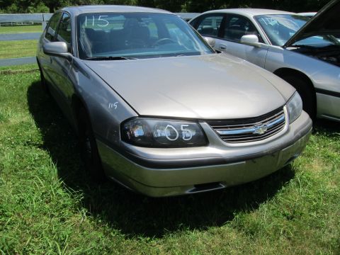 2001 Ford Crown Victoria - This tan Chevrolet Impala is shown from the front, with the number '05' written on its headlight.