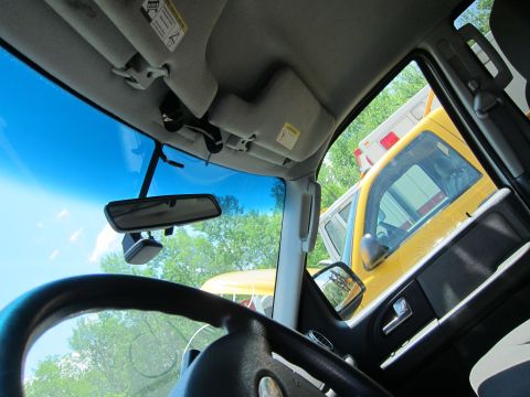 2001 Ford Crown Victoria - View from inside a vehicle shows two yellow emergency vehicles through the windshield and side window.