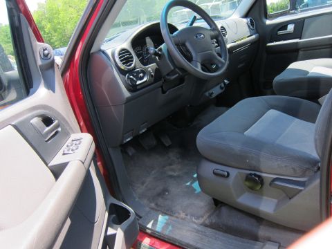 2001 Ford Crown Victoria - Interior view of a red SUV, showing dashboard, steering wheel, and seats.