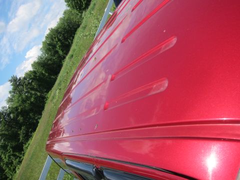 2001 Ford Crown Victoria - The top of a red vehicle is shown, a textured surface with raised ridges and a metallic sheen.
