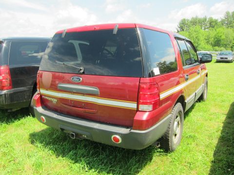 2001 Ford Crown Victoria - Rear view of a red Ford Expedition SUV with white and yellow stripes on the side.