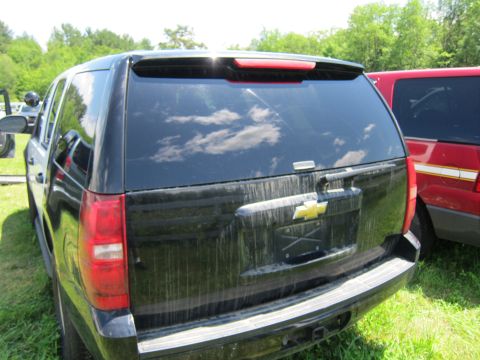 2001 Ford Crown Victoria - Rear view of a black Chevrolet Tahoe parked next to a red SUV.