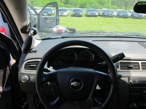 2001 Ford Crown Victoria - Interior view of a Chevrolet vehicle with a line of parked cars visible through the open door.
