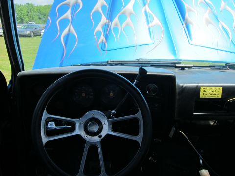 2001 Ford Crown Victoria - The interior of a car is visible, with a custom steering wheel and a blue hood adorned with flame graphics.