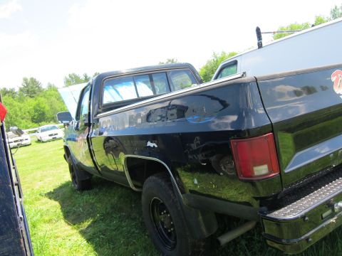 2001 Ford Crown Victoria - A black pickup truck is parked on grass with its hood open. Another vehicle is visible in the background.