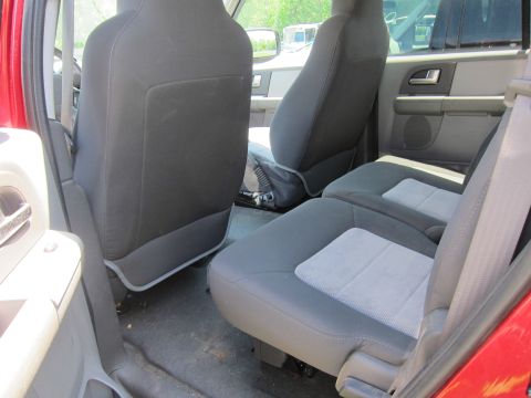 2001 Ford Crown Victoria - Rear seating area of a red SUV, with dark fabric seats and light grey inserts.