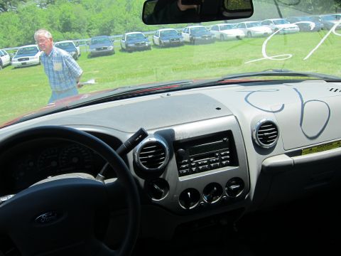 2001 Ford Crown Victoria - A man inspects a line of parked cars from the interior of another vehicle.