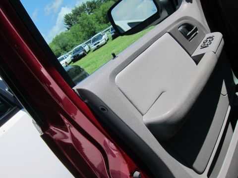 2001 Ford Crown Victoria - View of a car's interior door panel, showing window controls and a glimpse of other vehicles parked outdoors.