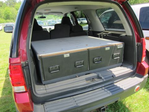2001 Ford Crown Victoria - The rear of a red SUV is open, showing a custom storage unit with two drawers fitted into the cargo space.