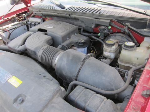 2001 Ford Crown Victoria - Close-up view of a red vehicle's engine bay, showing various components and hoses.