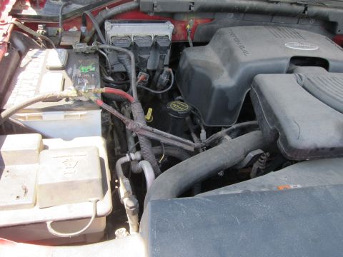 2001 Ford Crown Victoria - Close-up view of a vehicle's engine bay, showing the battery and engine components.