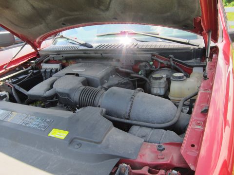 2001 Ford Crown Victoria - The engine compartment of a red vehicle is shown with the hood open, revealing the engine components and fluids.
