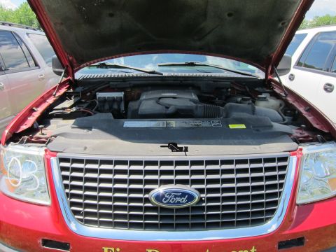 2001 Ford Crown Victoria - Front view of a red Ford SUV with the hood open, revealing the engine compartment and a prominent Ford emblem on the grille.